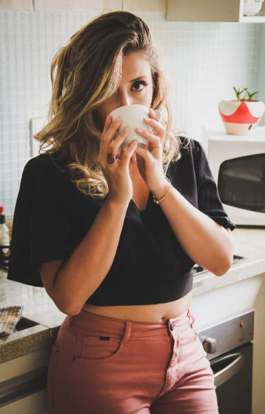 A woman sipping on cinnamon matcha latte.