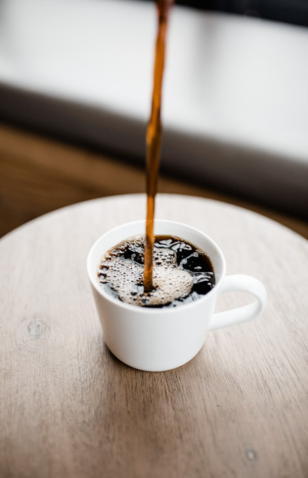 A person pouring Chaga-infused coffee in a cup.